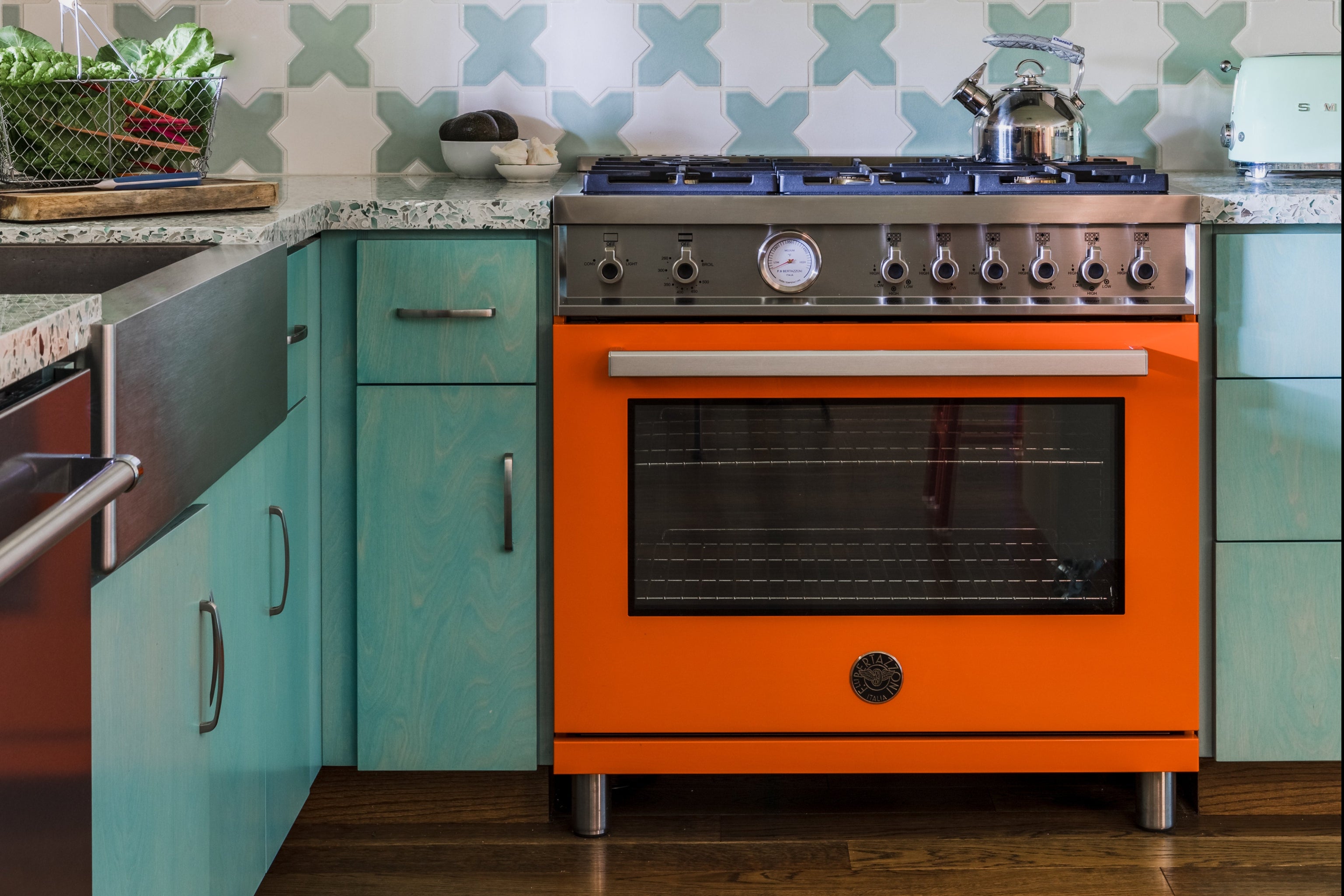 Kitchen with an orange oven and patterned backsplash